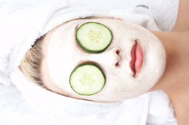 Girl witn facial mask and cucumber on her eyes